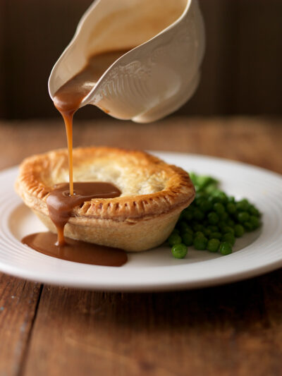 pouring gravy onto a pie